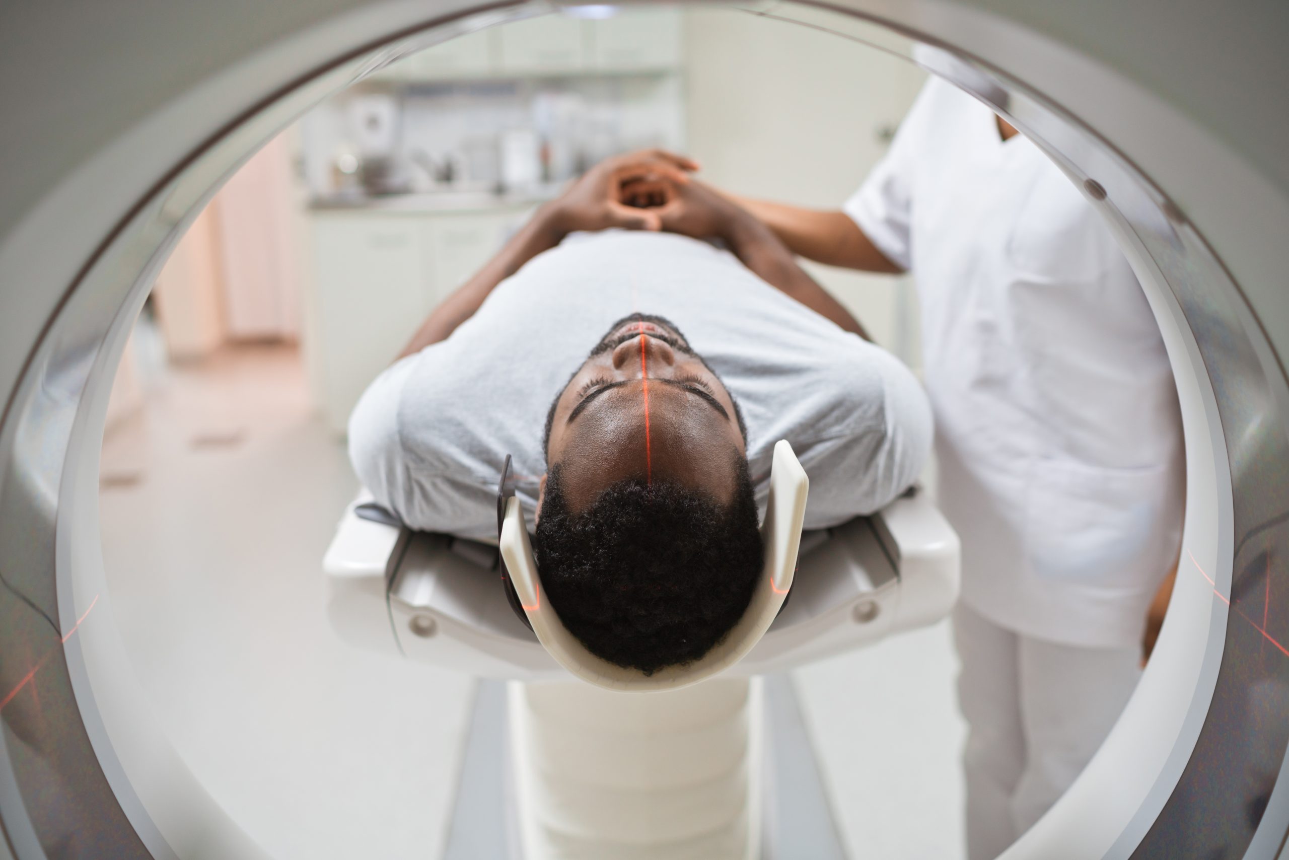 A man lying down on a slab and preparing to be moved into an MRI machine