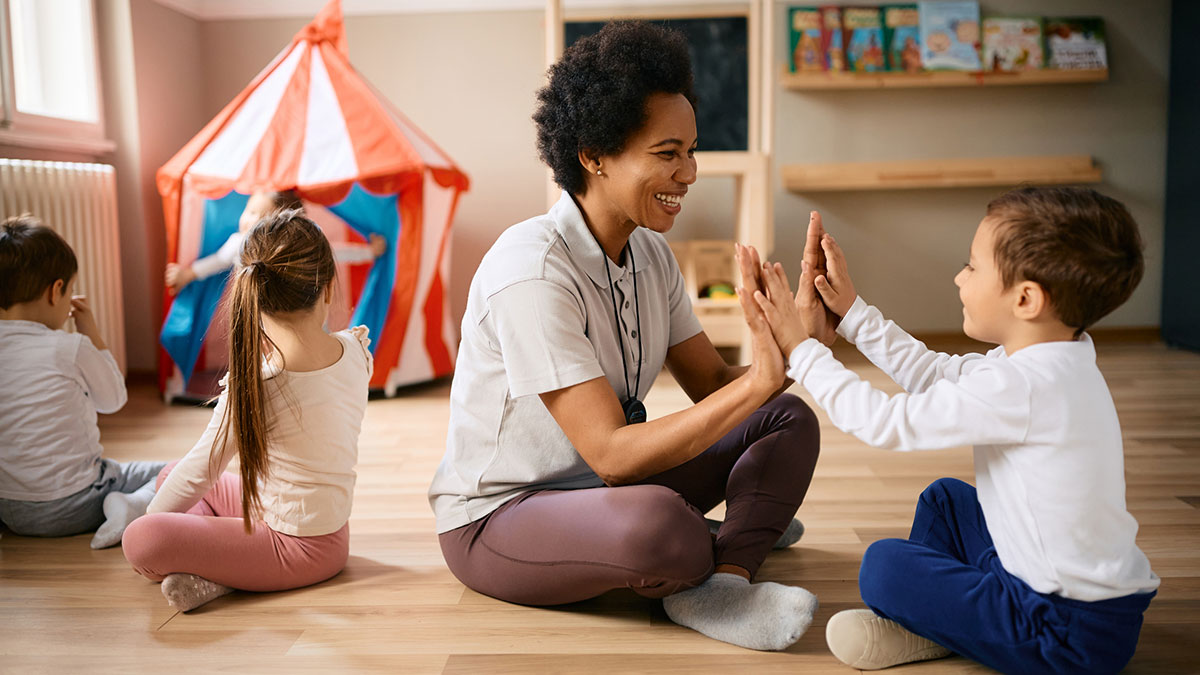 Early intervention teacher engaging with children.