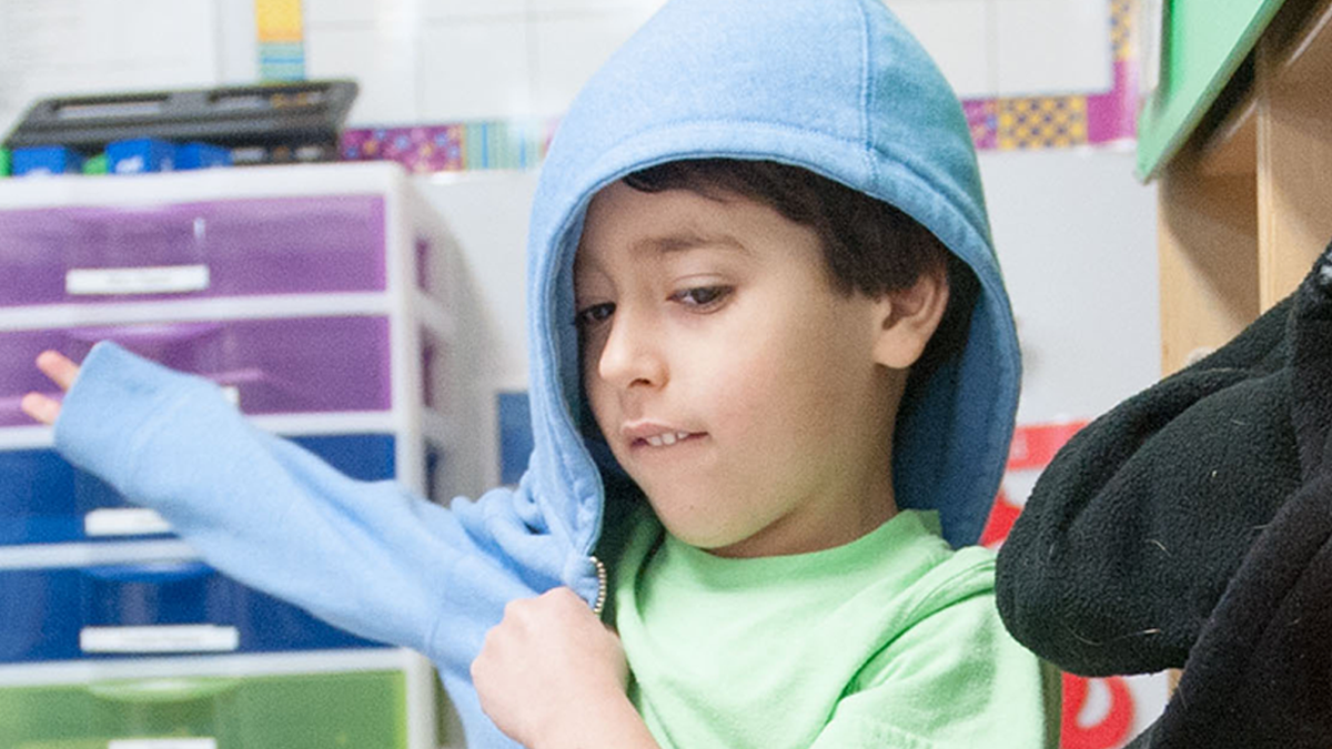 3 years old child putting on jacket