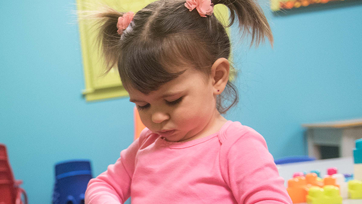 30 month old girl playing with bottle