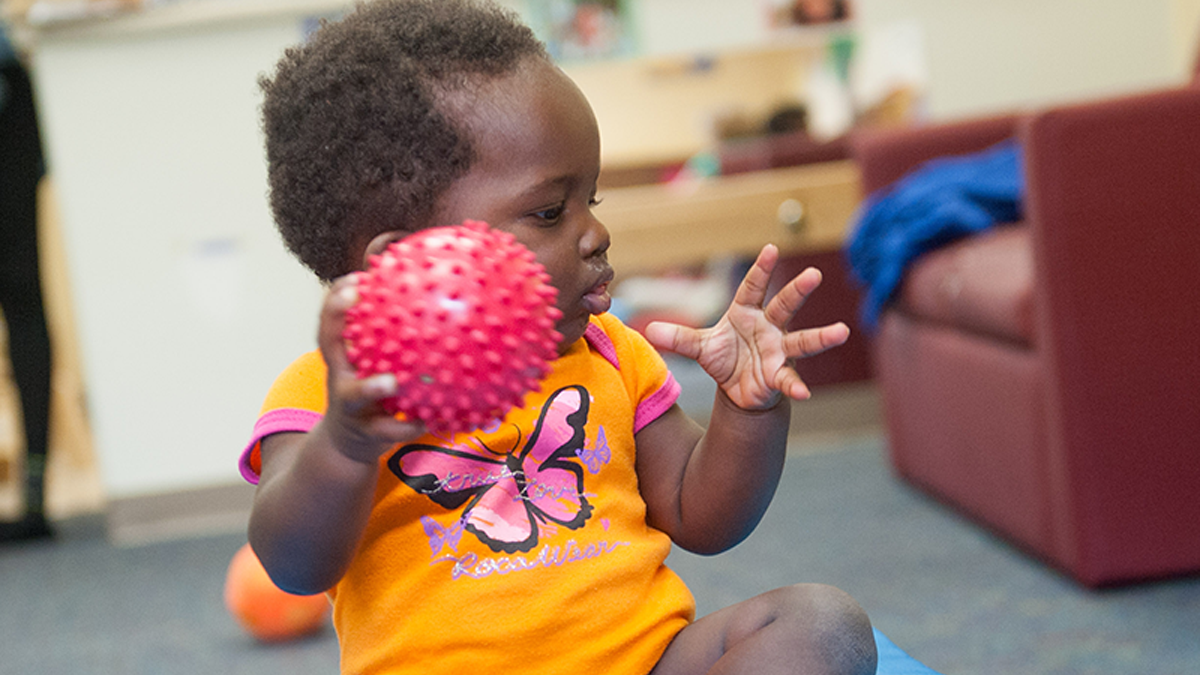 9-month-old child playing with a ball