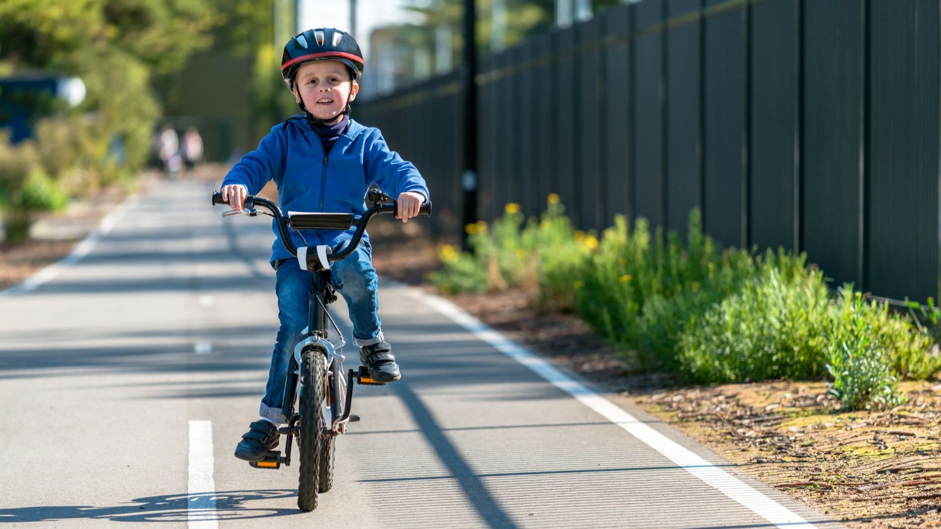 — title missing — Boy riding in bike lane.