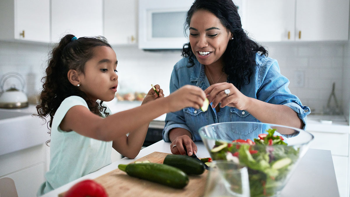 Girl helping her mother prepare meal