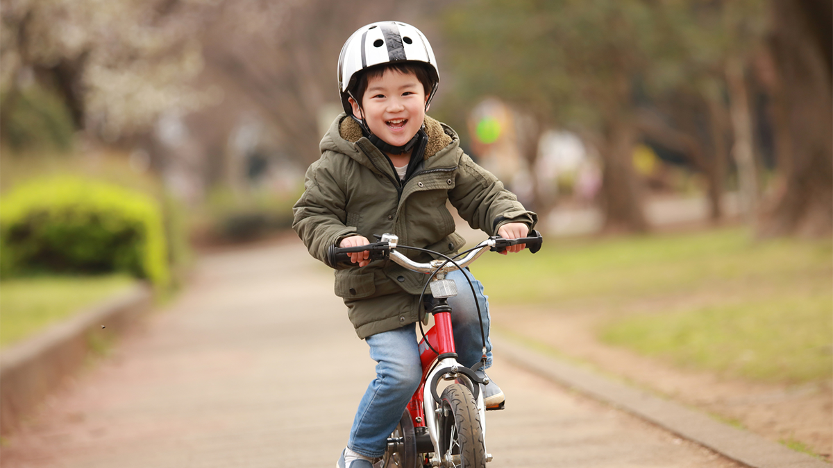 Ni&ntilde;o andando en bicicleta felizmente.