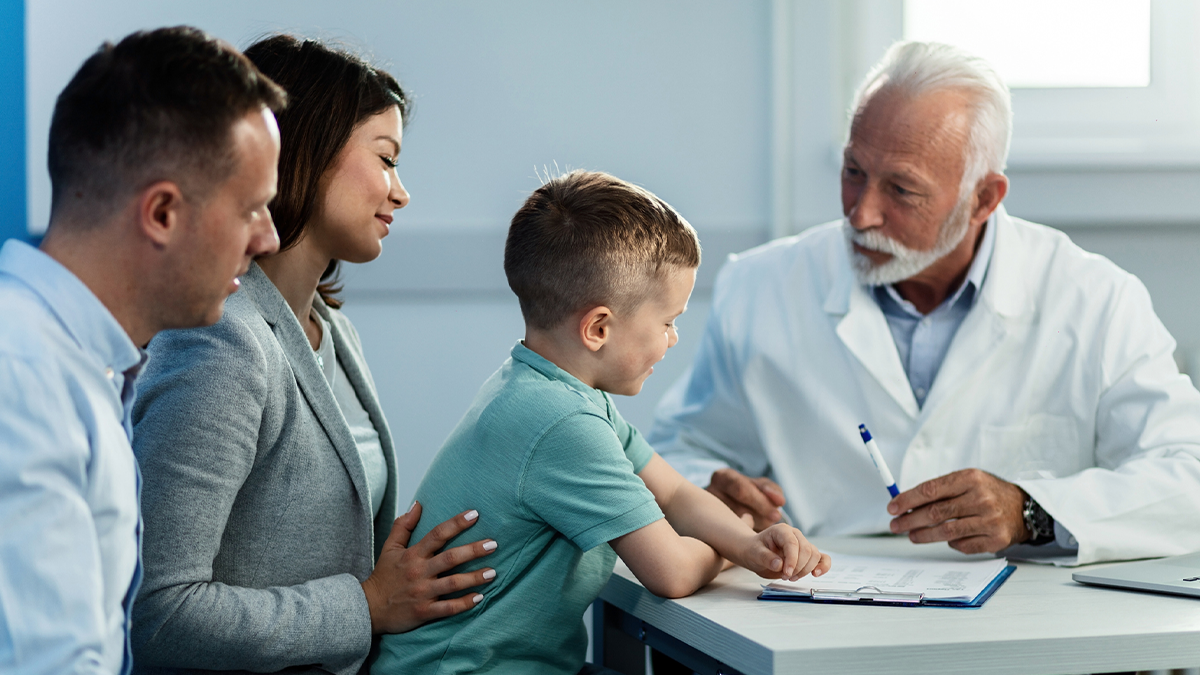 Doctor meeting with parents and their son in office to discuss treatment plans.