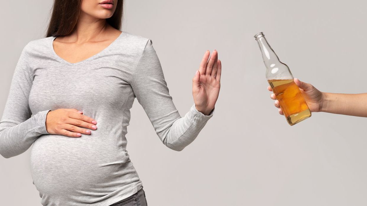 A pregnant woman refusing an alcoholic drink