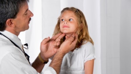 Healthcare provider examining a child to determine if she has cat scratch disease.