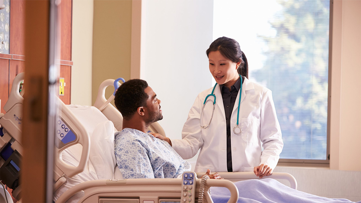 Understanding your risk for HAVTE Female doctor talking to African American man laying in hospital bed