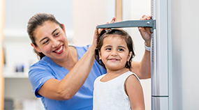 child measuring Health care professional measuring child's height
