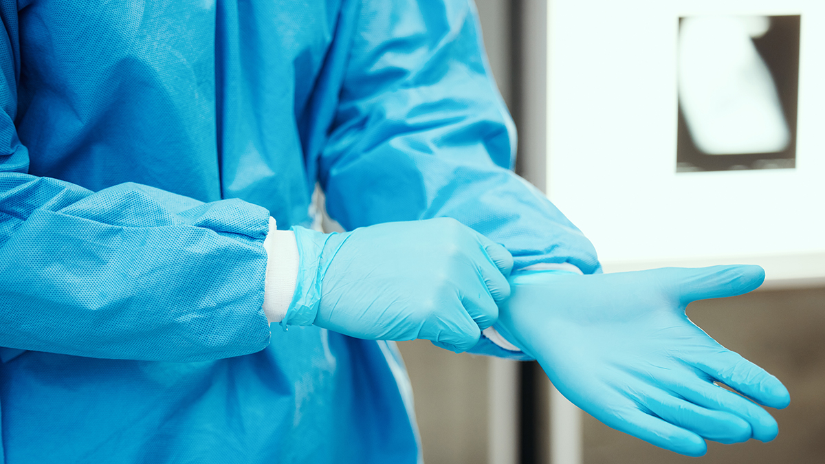 Healthcare professional donning personal protective equipment