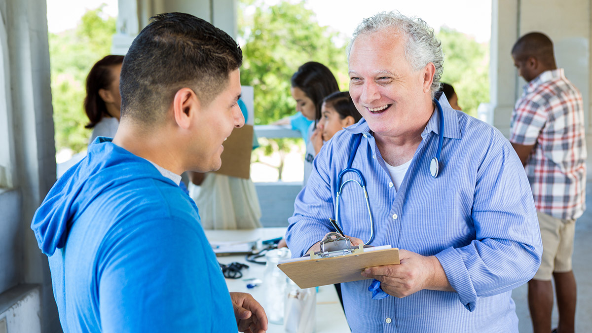 workplace-health Smiling doctor speaking with an employee in the workplace.