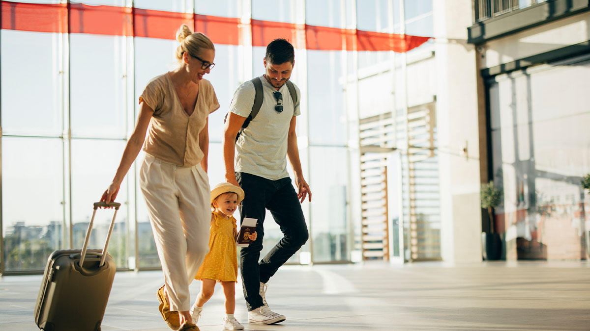 Mother and father walking next to daughter in airport