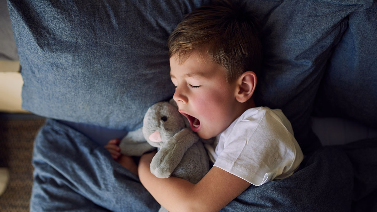 A child sleeping with stuffed bunny
