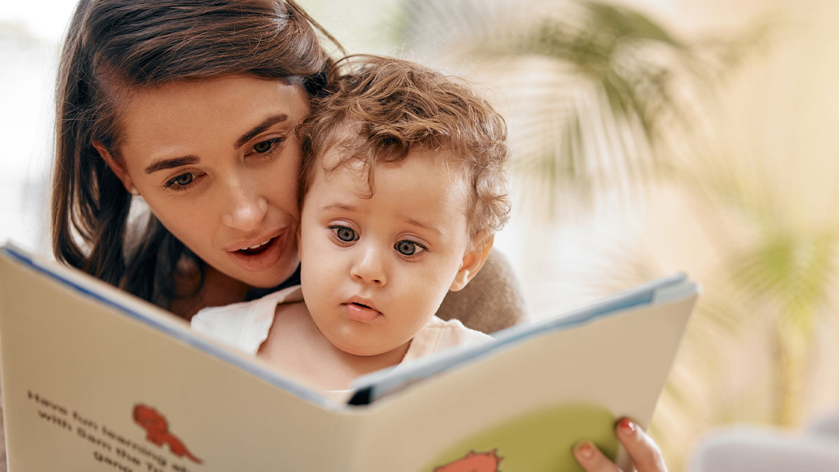 Mother reading a book to her toddler.