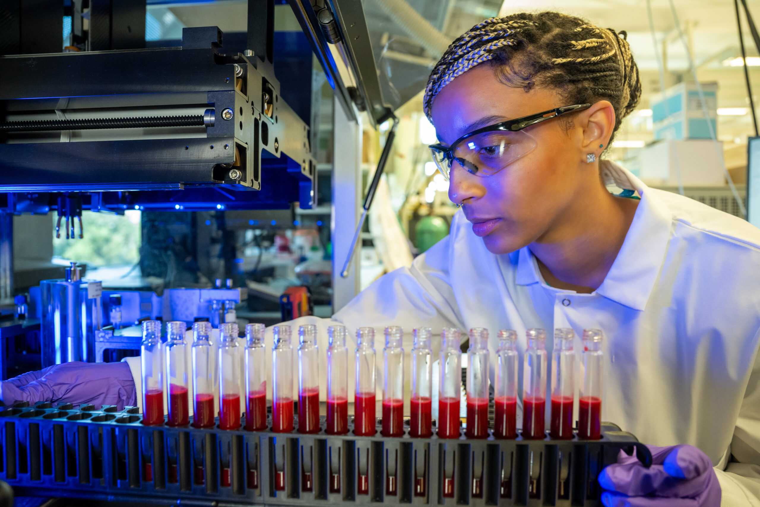 A laboratory scientist is loading blood samples into an instrument.