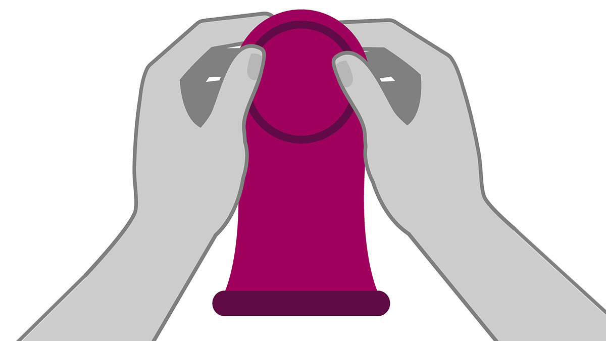 Un par de manos sosteniendo un cond&oacute;n femenino desde el anillo grueso, interno.