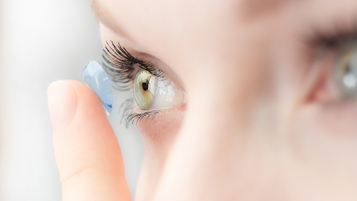 Woman putting on a contact lens