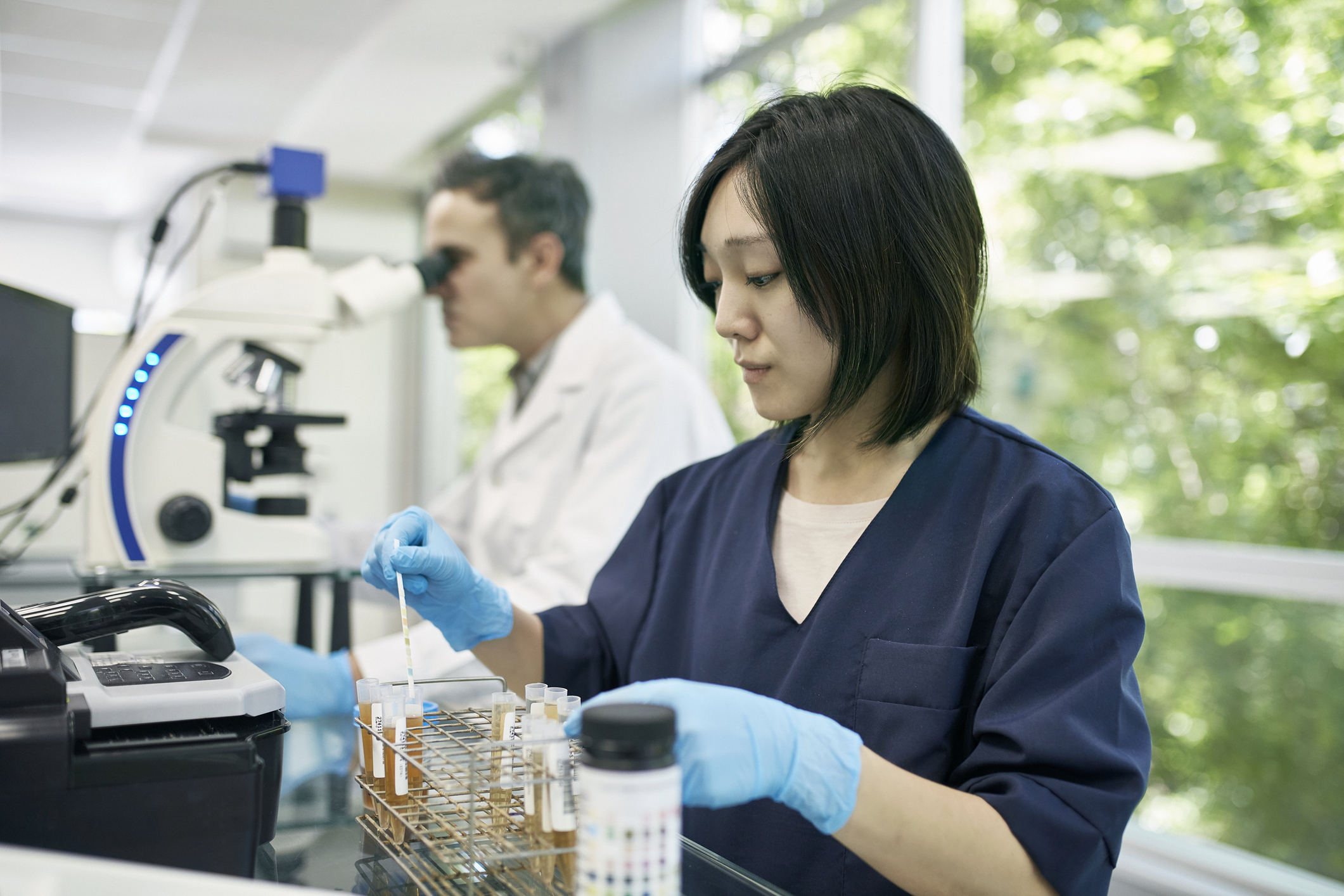 Lab analysis A laboratory worker performing analysis on samples in test tubes.