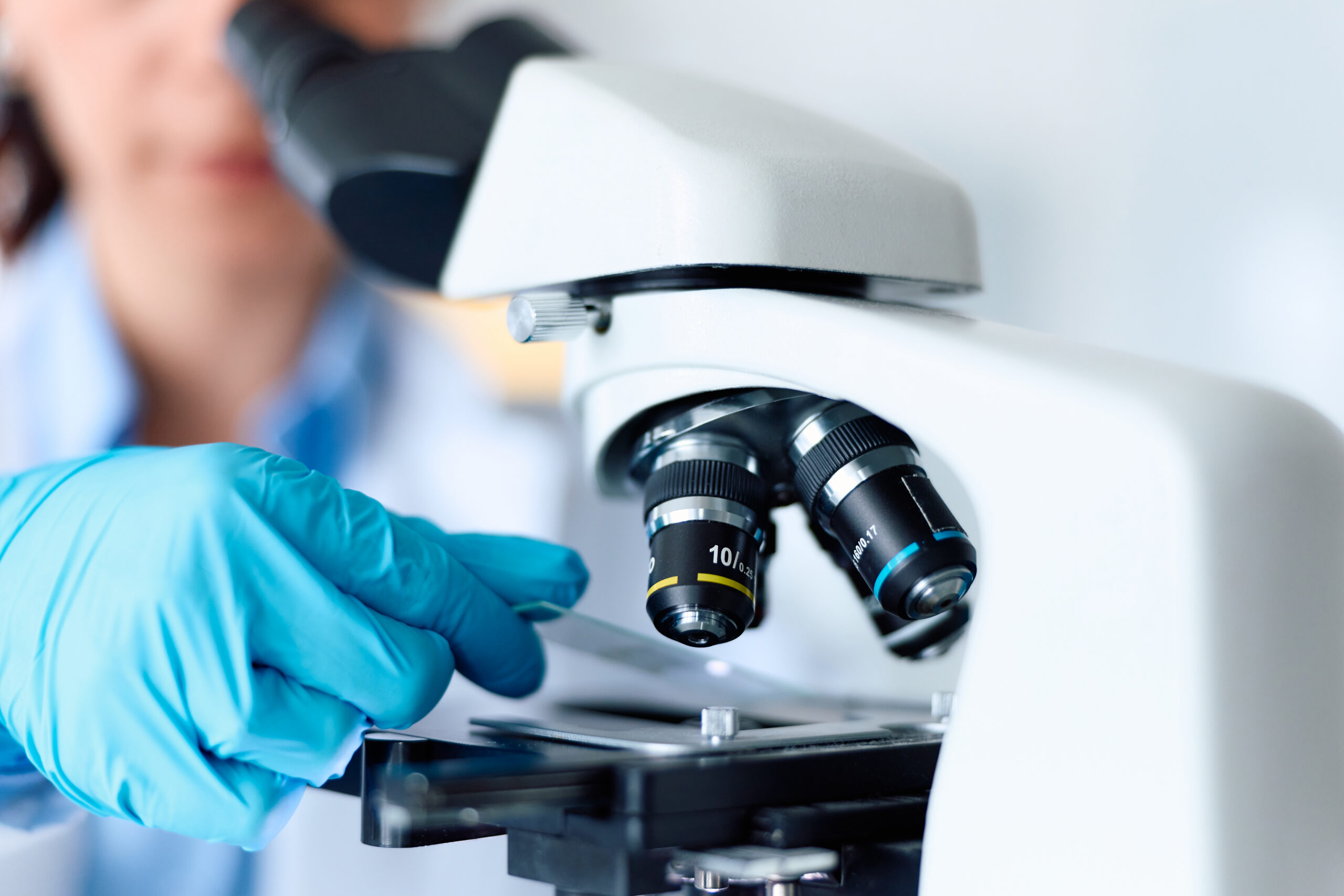 Closeup of scientist loading slide into a microscope