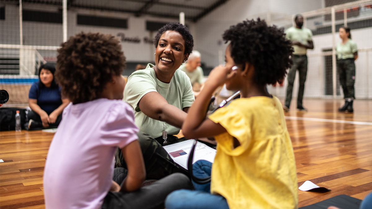 — title missing — Community worker playing with kids at a community center