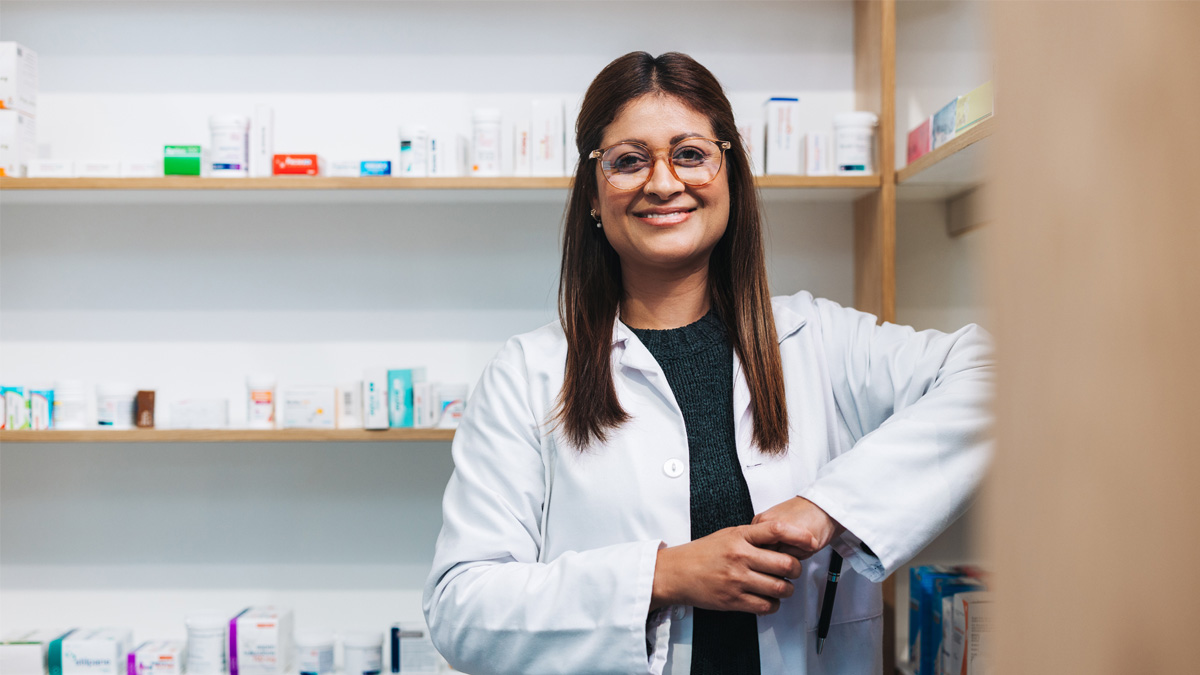 — title missing — Pharmacist standing in a drug store and looking at the camera.