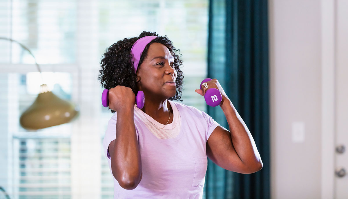 Senior woman working out at home in her living room