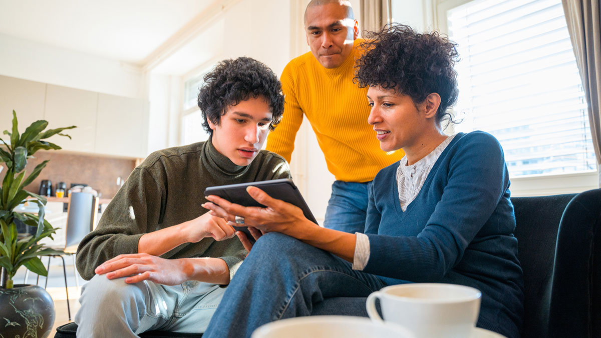 Family sitting on couch looking at ipad