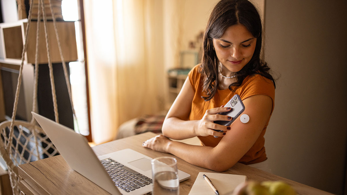 Woman using continuous glucose monitor