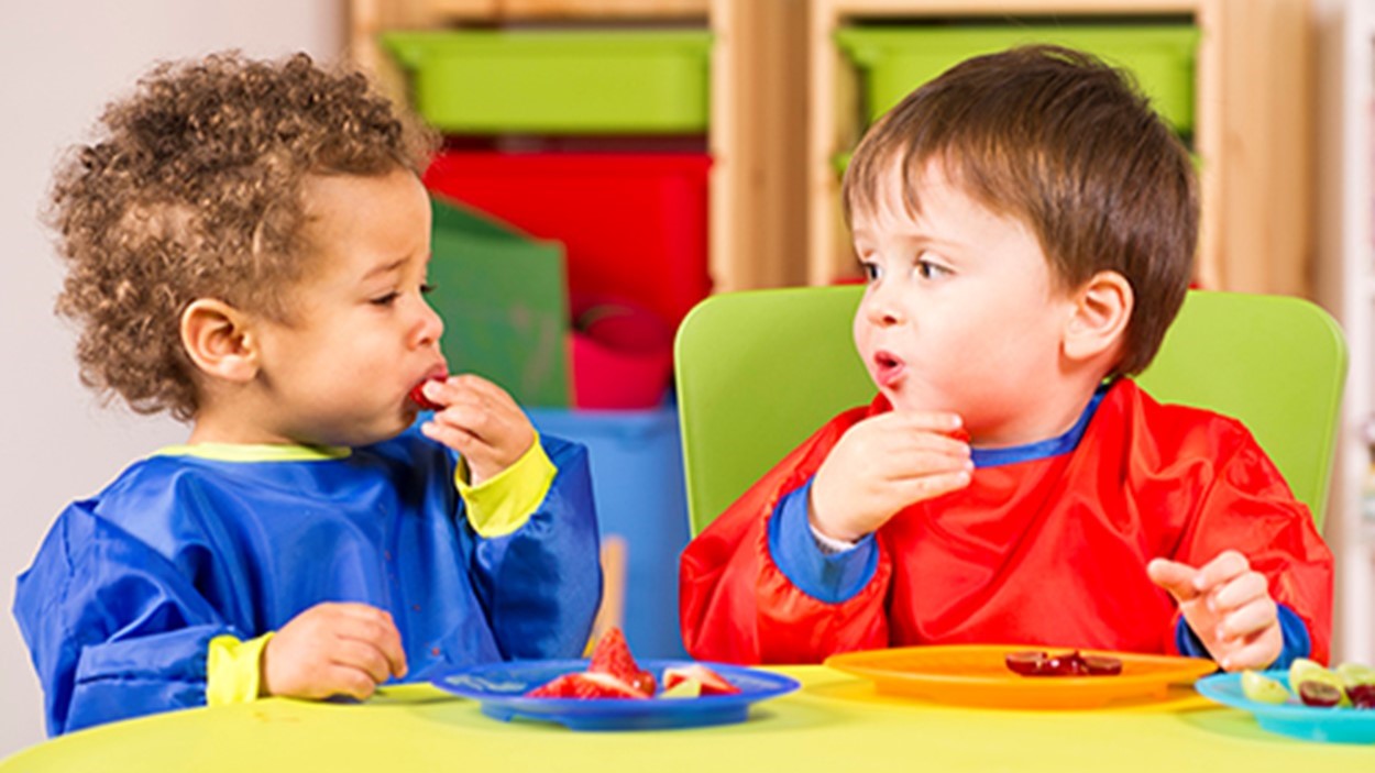 — title missing — Young children eating strawberries.