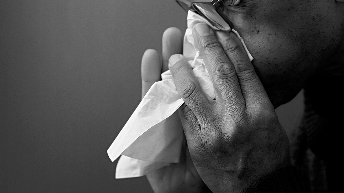 How Flu Spreads A picture of a person blowing their nose with a tissue.