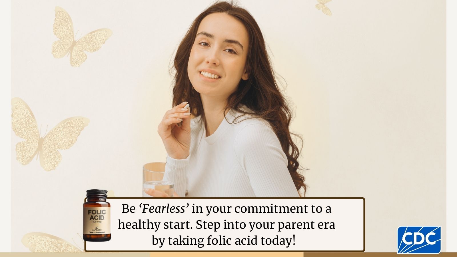 A young adult holding a folic acid vitamin while looking at the camera, butterflies are seen in the background.