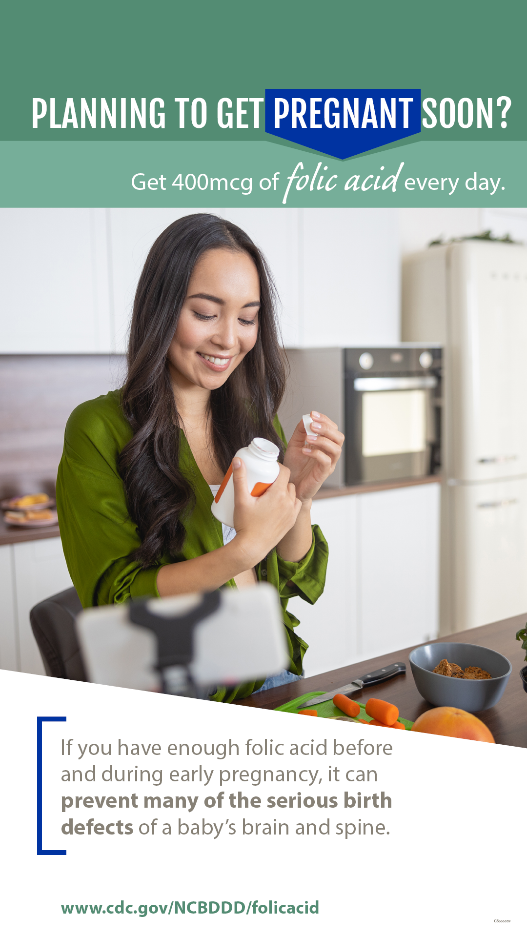 A person holding a vitamin bottle while in the kitchen reading the label.