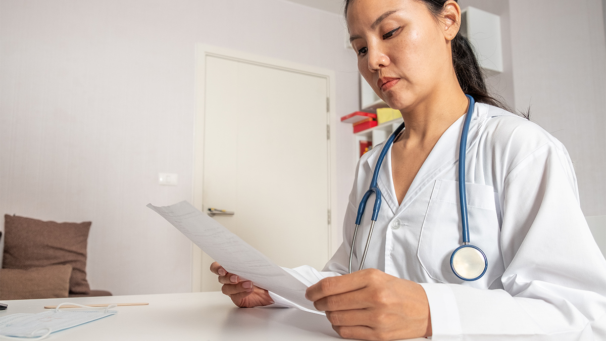 A female doctor reads paperwork