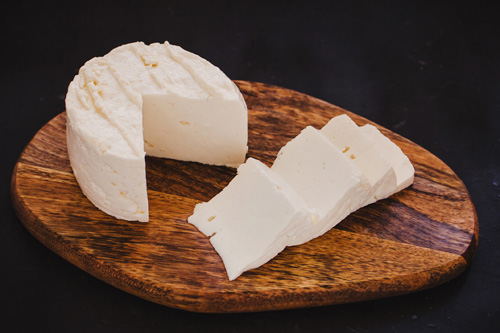 Cheese wheel on a cutting board Cheese wheel on a wood cutting board