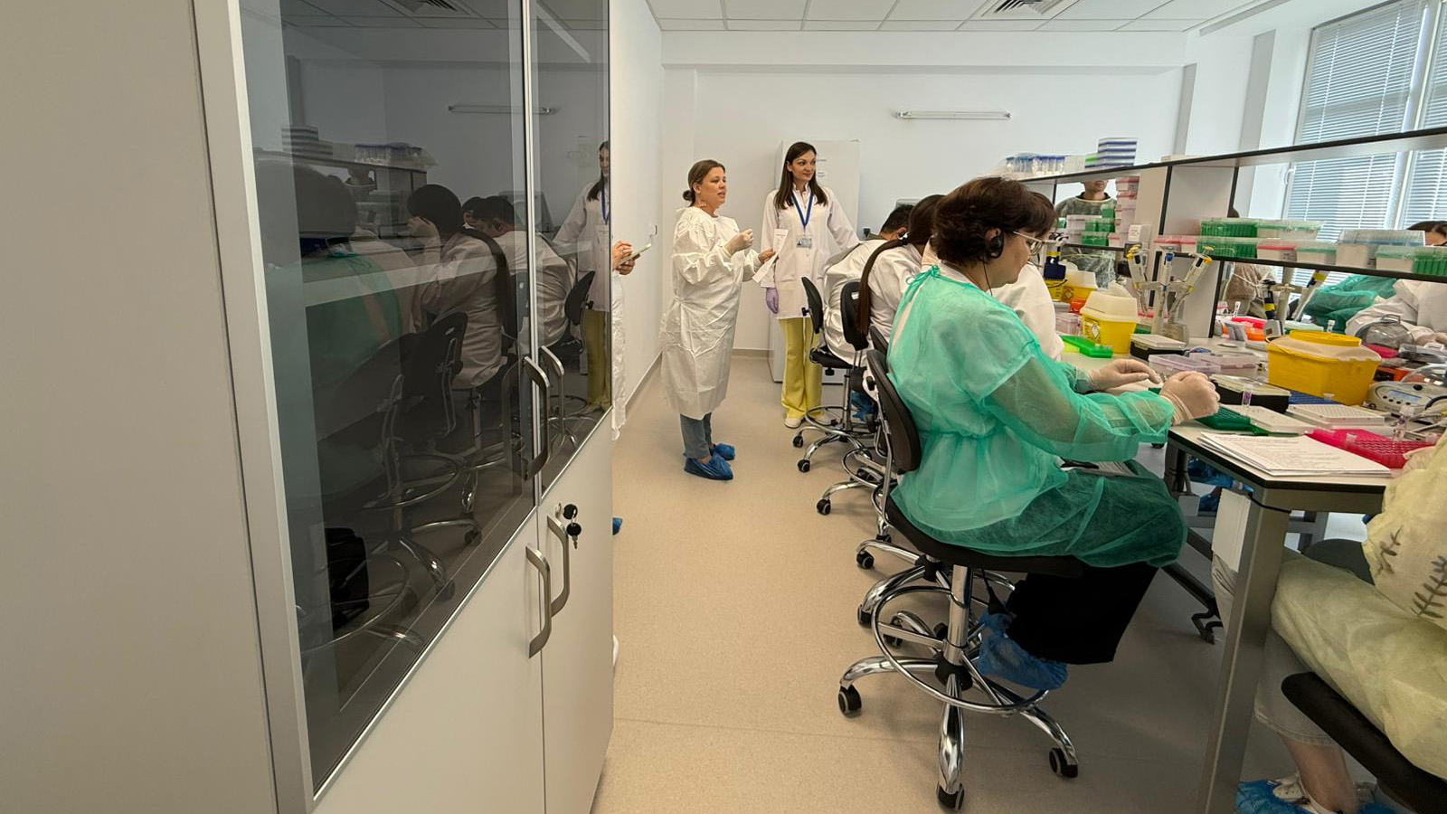 People in lab setting wearing personal protective equipment.