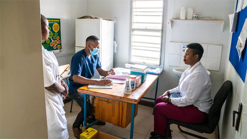 Three adults speaking in a clinic.