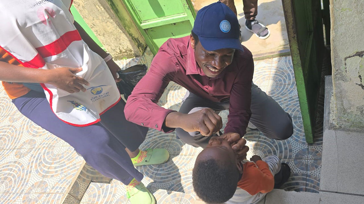 A doctor administers oral vaccine to a young child