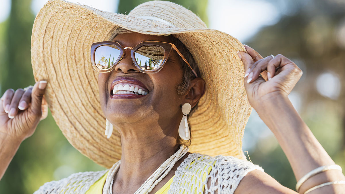 senior african american woman wearing sunglasses and hat Woman wearing sunglasses and sun hat outside