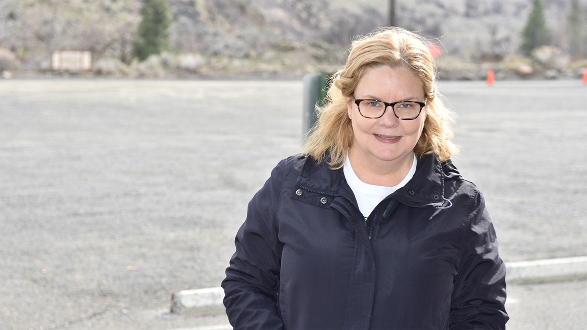 Jennifer Smiling woman standing in front of a mountain