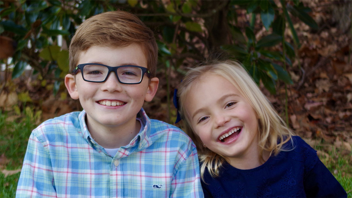 Nicholas and Aleesia Young boy and girl sitting under a tree and smiling