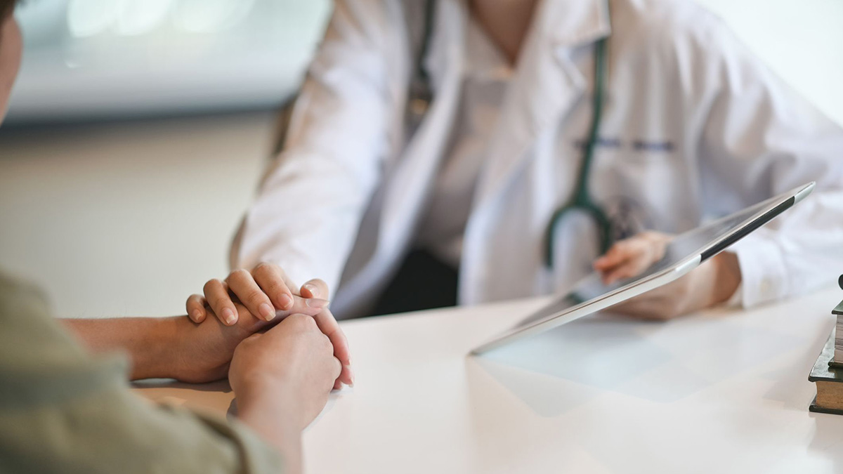doctor showing paitient tablet Lower body picture of a doctor showing information on a tablet to a patient