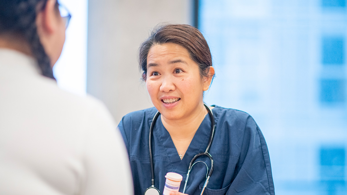 Hepatitis C Clinical Care and Treatment Thumbnail A healthcare professional holding a prescription bottle while meeting with a patient
