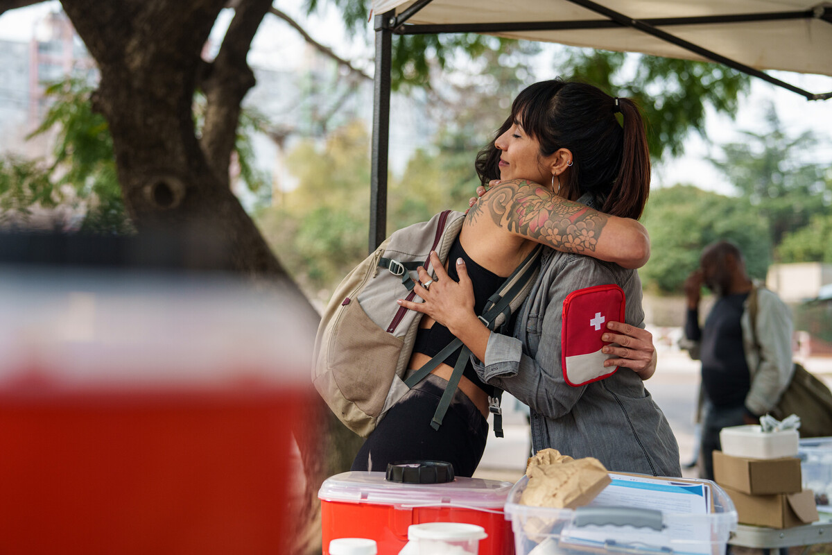 A woman who use or inject drugs and is susceptible to viral hepatitis hugging a first air worker