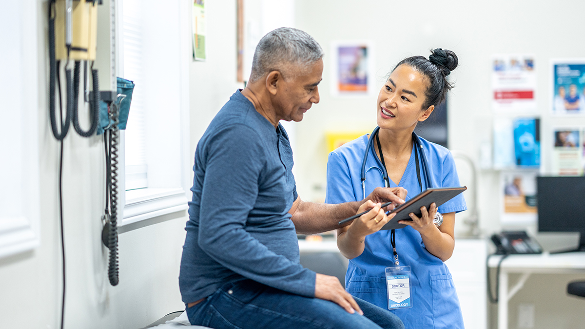 Health care professional measures blood pressure of older woman