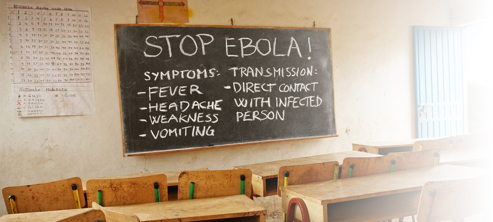 Classroom with Ebola prevention guidance written on a chalkboard.