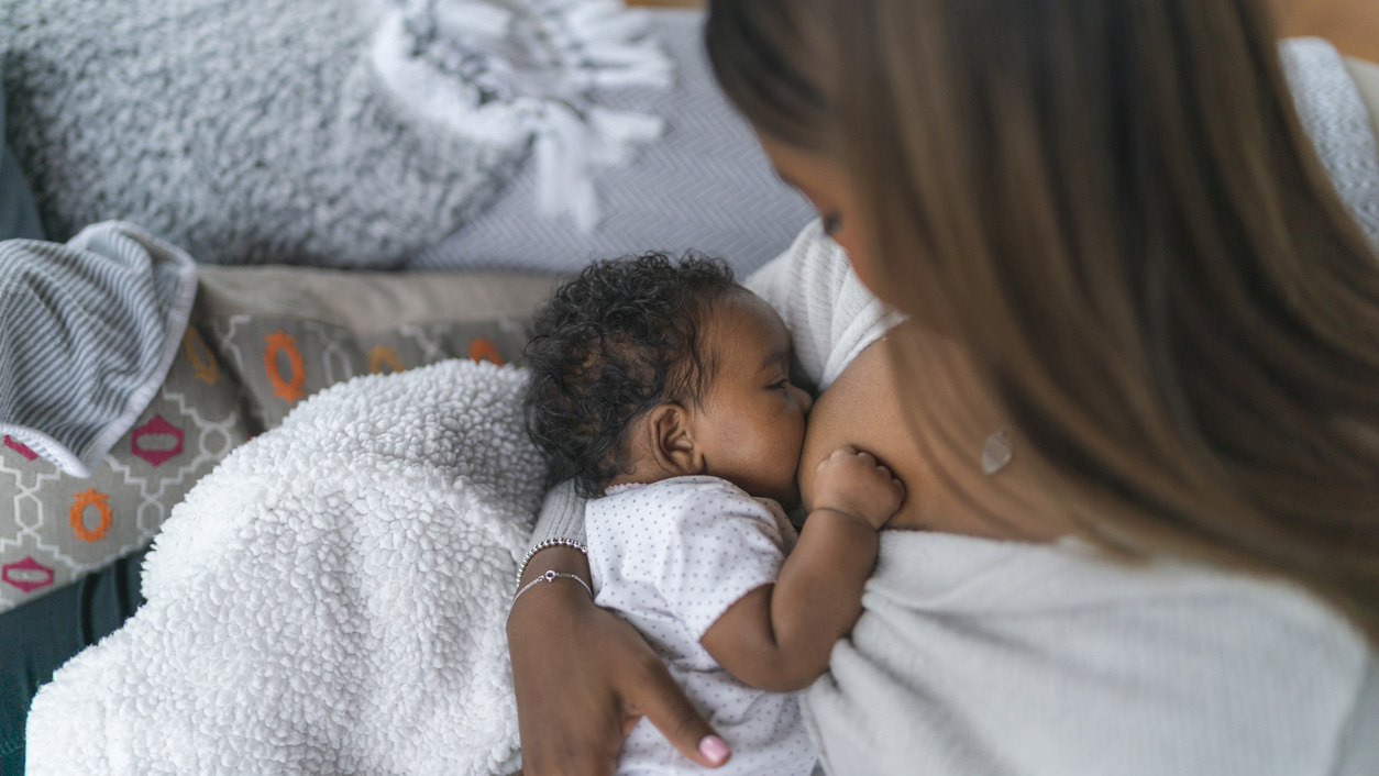 A newborn baby breastfeeds