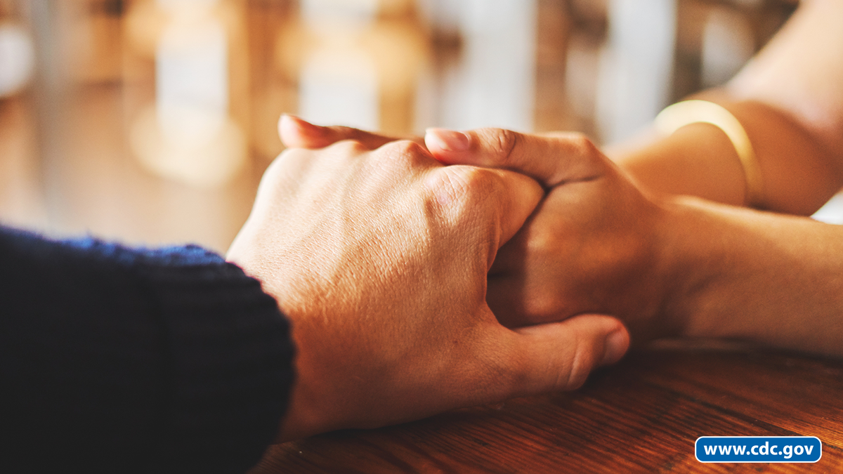 suicide prevention hands Two people hold hands in a supportive way