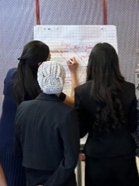 Attendees working through an exercise at a white board during a training session.