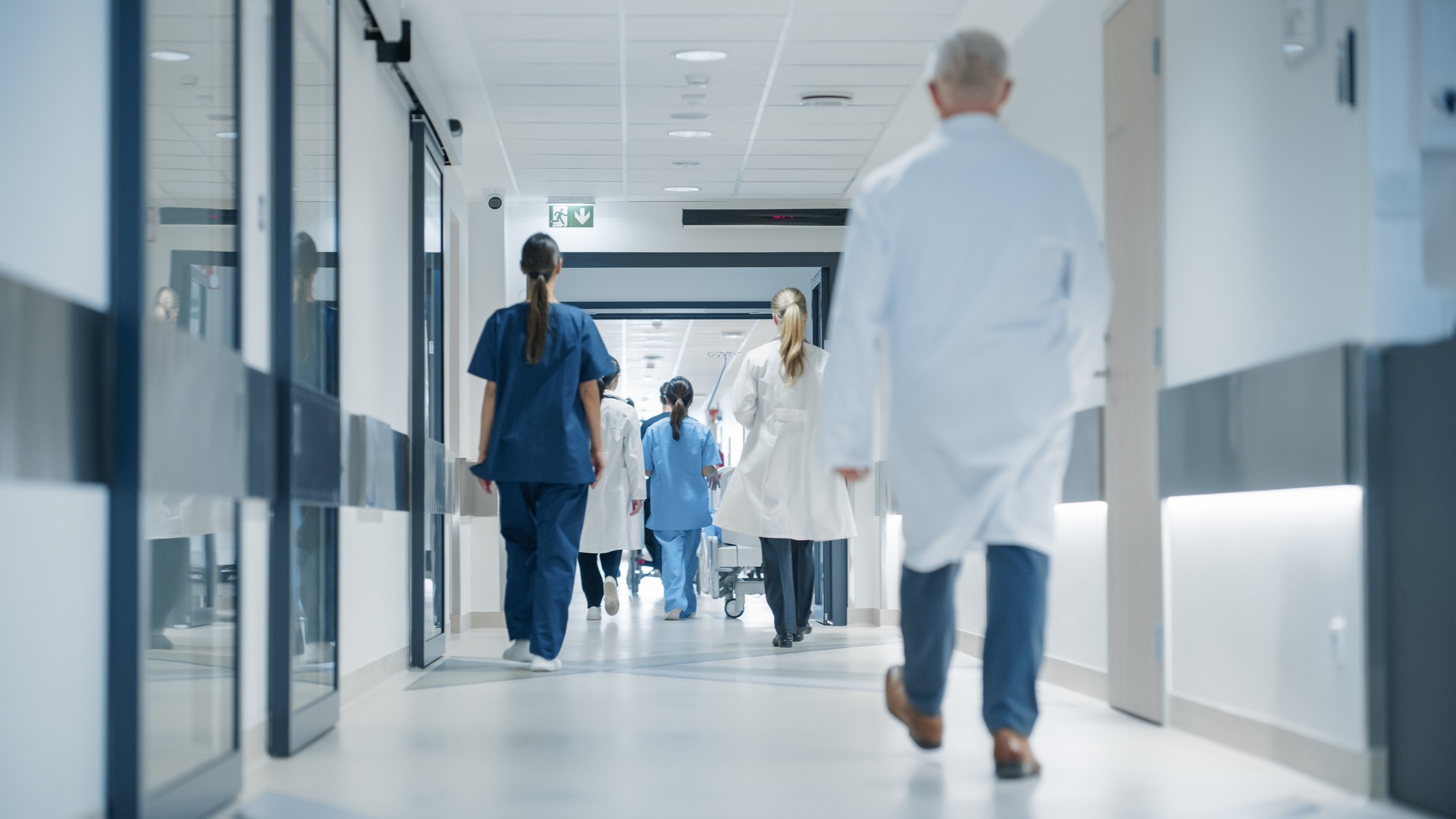 Healthcare workers walking down the hallway at a hospital.