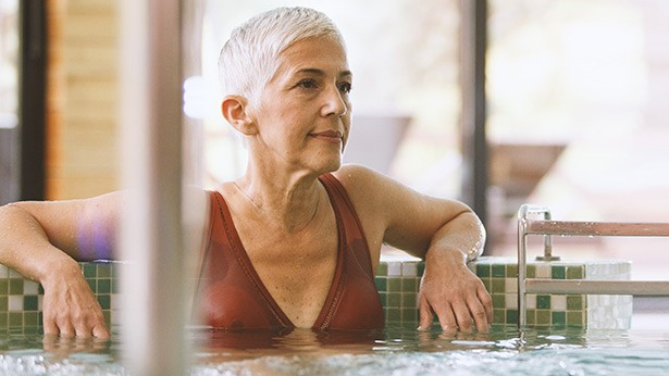 Una mujer mayor relajándose en una bañera de hidromasaje